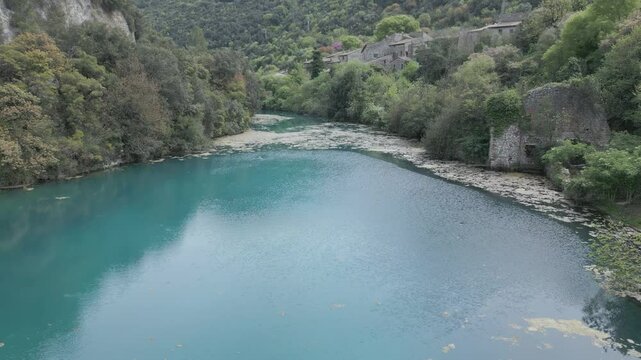 Drone footage of Stifone and the Morica spring in Umbria, Italy: turquoise waters, lush nature, stone ruins, and peaceful river views in a hidden, historic valley.