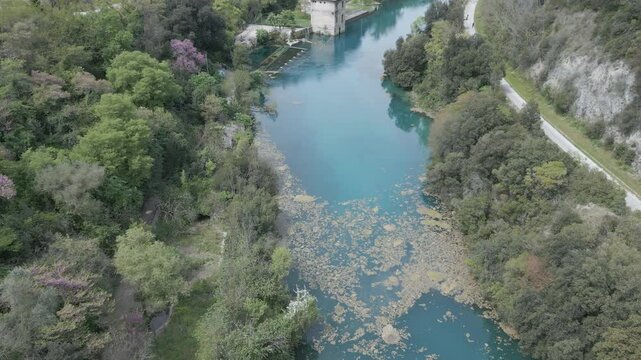 Drone footage of Stifone and the Morica spring in Umbria, Italy: turquoise waters, lush nature, stone ruins, and peaceful river views in a hidden, historic valley.