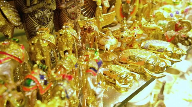 Rows of golden camels, scarab beetles and other trinkets on shelf of souvenir shop. Traditional egyptian souvenirs