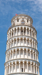 Iconic views of the Leaning Tower of Pisa under clear blue skies, showcasing the architectural...