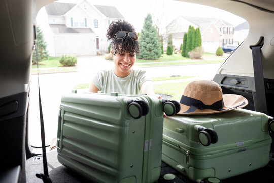 Woman loading luggage in trunk of SUV