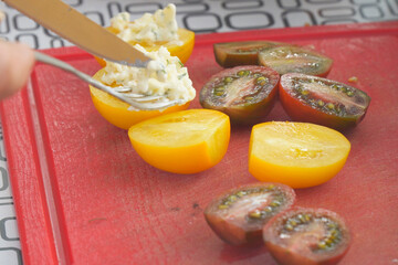 Slicing Tomatoes and Adding Cheese on Cutting Board