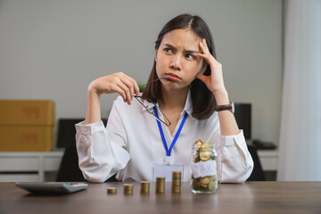 Business women use calculators To calculate the amount of tax to be paid, The coins in the bottle.