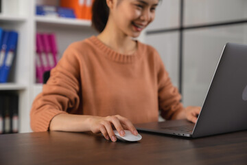Student studies online on laptop and writing on notebook.