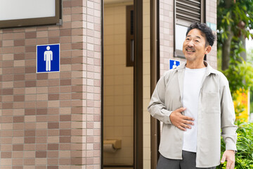 公衆トイレから出てきたミドル男性　ライフスタイルイメージ	
