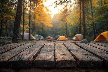 Empty wooden table overlooks camping tents in a forest during autumn