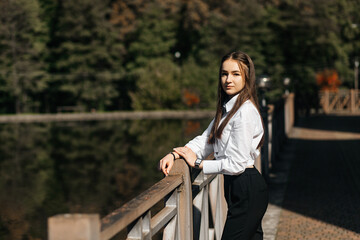 Girl in summer near an iron fence