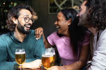 Multi-ethnic friends enjoying drinks and conversation at a bar, sharing laughter and good times together