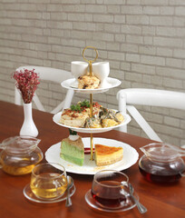 afternoon tea tier with various petit fours and many cups of tea