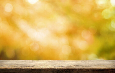 Wooden table on yellow orange light bokeh nature background. Soft focus autumn colors background...