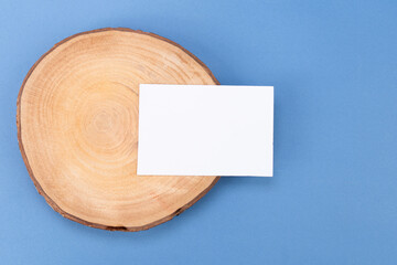 White blank business card mockup with wooden decoration on blue background