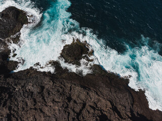 Aerial View of Waves Crashing on Rocky Shoreline