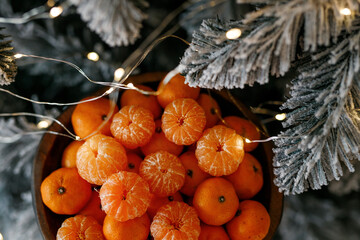 Plate with tangerines under a beautiful New Year tree. View from above