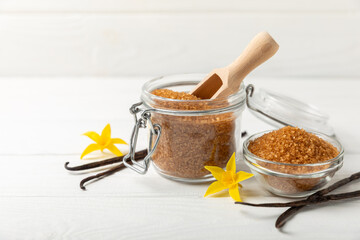 Aromatic vanilla sugar. Vanilla pods. Vanilla sticks, brown and white sugar in a bowl on a textured background. Vanilla flowers, spices and herbs for desserts and baking. Space for text. Copy space