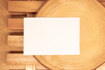 White blank business card mockup with wooden decoration on wooden background