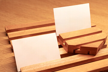 White blank business card mockup with wooden decoration on wooden background