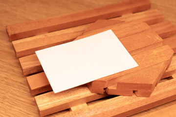 White blank business card mockup with wooden decoration on wooden background