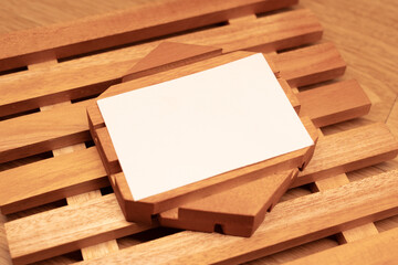 White blank business card mockup with wooden decoration on wooden background