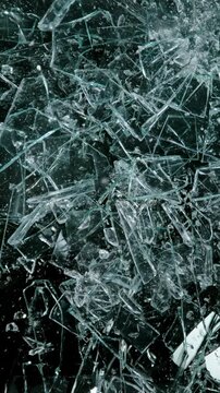 Super slow motion of broken glass, shattering against black background . Filmed on high speed cinema camera, 1000 fps.