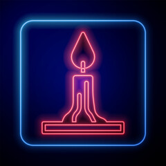 Glowing neon Burning candle in candlestick icon isolated on black background. Cylindrical candle stick with burning flame. Vector