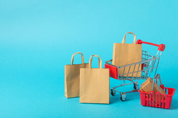 Online shopping concept.Cardboard box and shopping bags in a trolley on a bright colored...