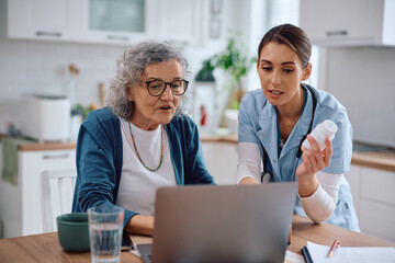 Healthcare assistant and senior woman using laptop while searching medicine online.