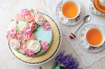 a beautiful flowery decorated cake and a cup of tea
