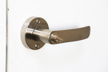 Detail of a metallic knob on white door horizontal