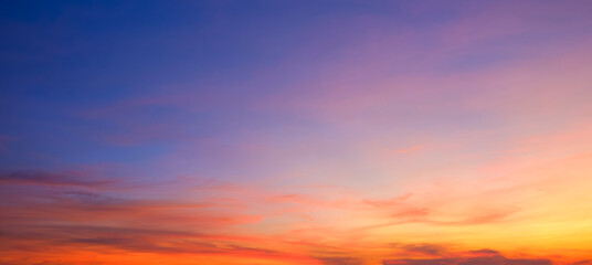 Evening sky background after sundown with dramatic dusk clouds and colorful orange yellow natural...