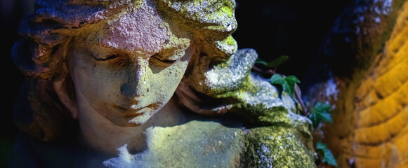 Beautiful angel as symbol of death, pain, fear and end of life. Ancient stone statue. Fragment....