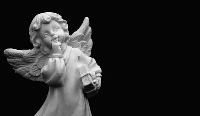 Little cute guardian angel against black background. Copy space.