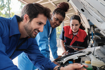 EV car check, mechanic coworkers, and inspector check and maintain service of electric engine and battery in fixed automobile garage station, professional technology transportation industry business.