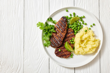 grilled beef cutlets with potato mash, green peas