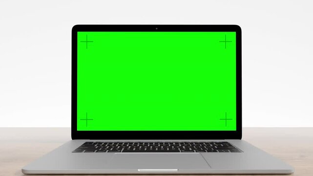 Laptop opens up in a white room, camera zooms into green screen with tracking markers. 3D animation.