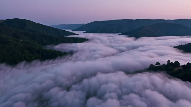 Fog rolling over forested mountain valleys at dusk
