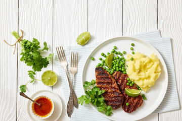 grilled beef cutlets with potato mash, green peas