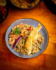 Spaghetti with shrimp as topping. Italian fusion with Indonesian dish. Served on grey bowl with crackers, sliced onion and scrambled egg. Flatlay angle. Perfect for advertising or commercial purpose