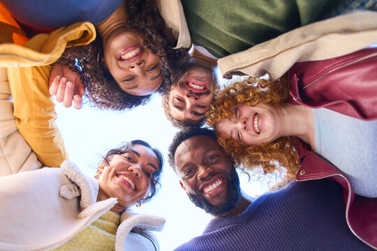 Happy multi ethnic friends forming a circle and smiling