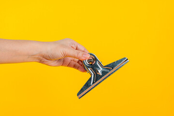 Stainless Steel Strips For clothespin or paper and hand on yellow background.