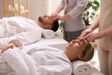 Couple receiving relaxing massage in spa salon, selective focus