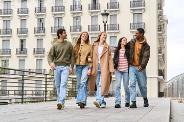 Happy multi ethnic friends walking together in the city