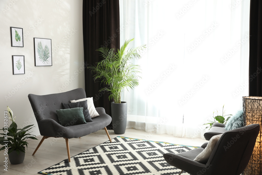 Poster comfortable sofa near window with elegant curtains in room