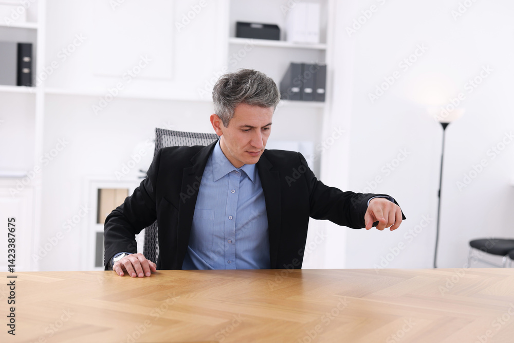 Poster man pointing at something on desk in office