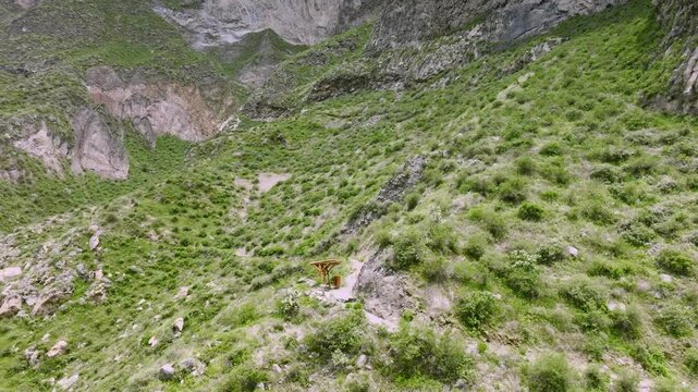 Drone shot capturing a resting spot along the ascent of the trekking path towards San Miguel, with hikers taking a break while surrounded by the rugged terrain and stunning views of the Colca Canyon.