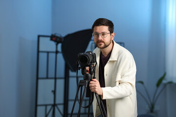 Man with professional video camera in studio