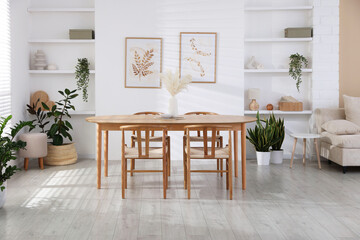 Stylish wooden table with chairs and decor indoors. Interior design