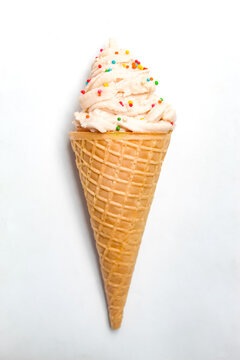 vanilla ice cream cone with sprinkles, isolated on white background