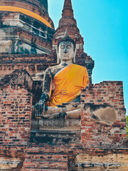 Close-up view of large Buddha statue draped in yellow robes in Ayutthaya, Thailand.