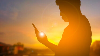 a man playing phone silhouette sunset