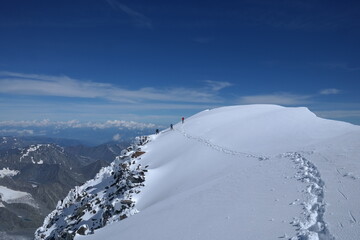 Adventurous hiker enjoying the breathtaking view from a snowy mountain peak